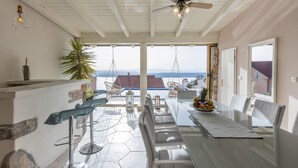 A spacious patio with a dining table, chairs, and a hanging chair overlooking a scenic view. - Awesome apartment in Dramalj with sauna (Dramalj)