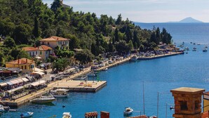Une ville côtière dotée d’un port de plaisance, de bâtiments le long du front de mer et d’une montagne en arrière-plan.