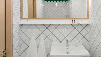 A bathroom with a white sink, a mirror above it, and a green ceiling.