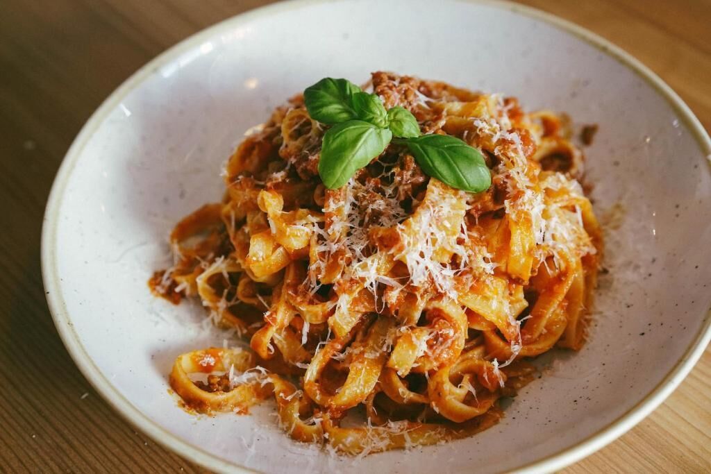 A plate of pasta with a basil garnish.