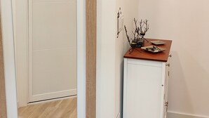 Une pièce dotée d’une porte coulissante, d’une petite armoire contenant des objets décoratifs et d’une étagère sur laquelle est posé un panneau.