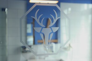 A glass partition with a geometric deer logo.