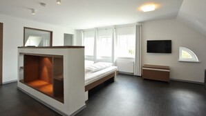 Un dormitorio moderno con cama tipo litera, televisor de pantalla plana y un amplio ventanal.