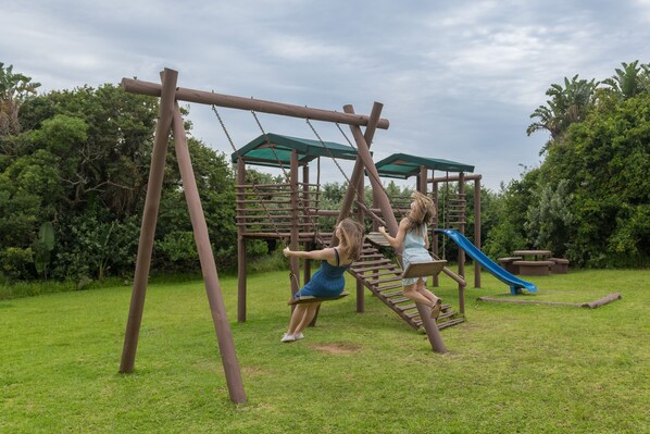 A playground with swings and a slide.