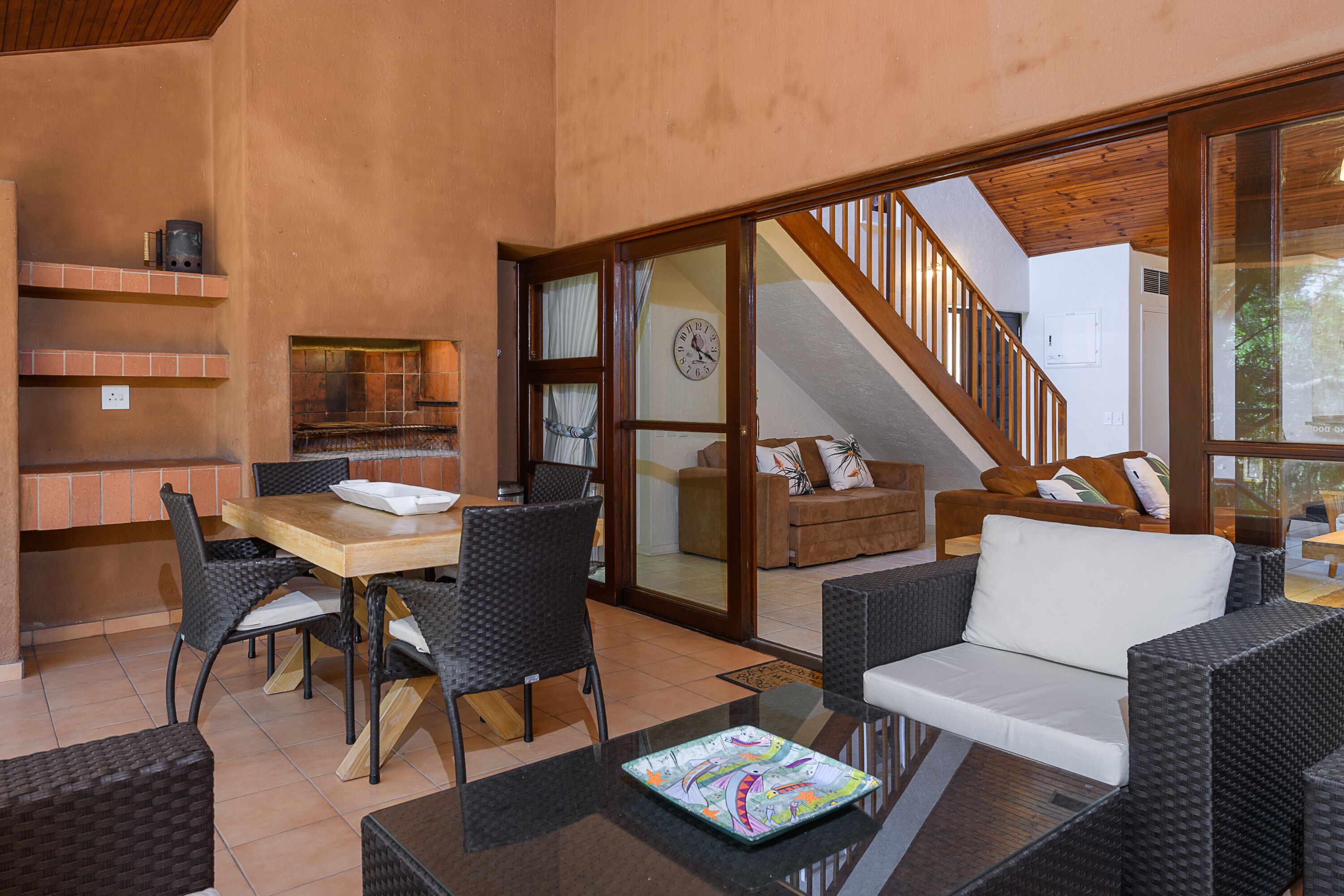 Eine geräumige Terrasse mit Esstisch und Stühlen, einer Couch und einem Fernseher.