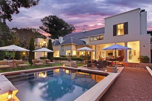 A modern house with a swimming pool, outdoor furniture, and a patio area. - Stellenbosch Manor (Stellenbosch)