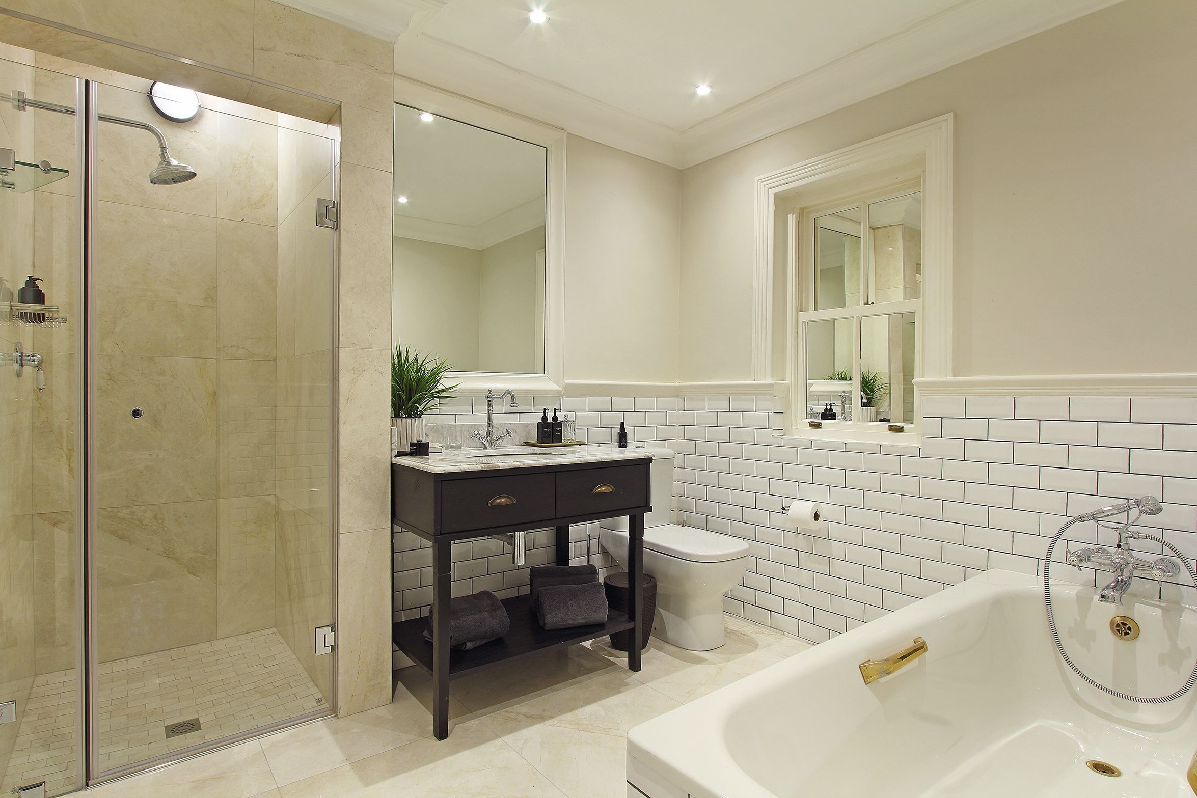 A modern bathroom with a glass-enclosed shower, a vanity with a mirror, a toilet, and a bathtub.