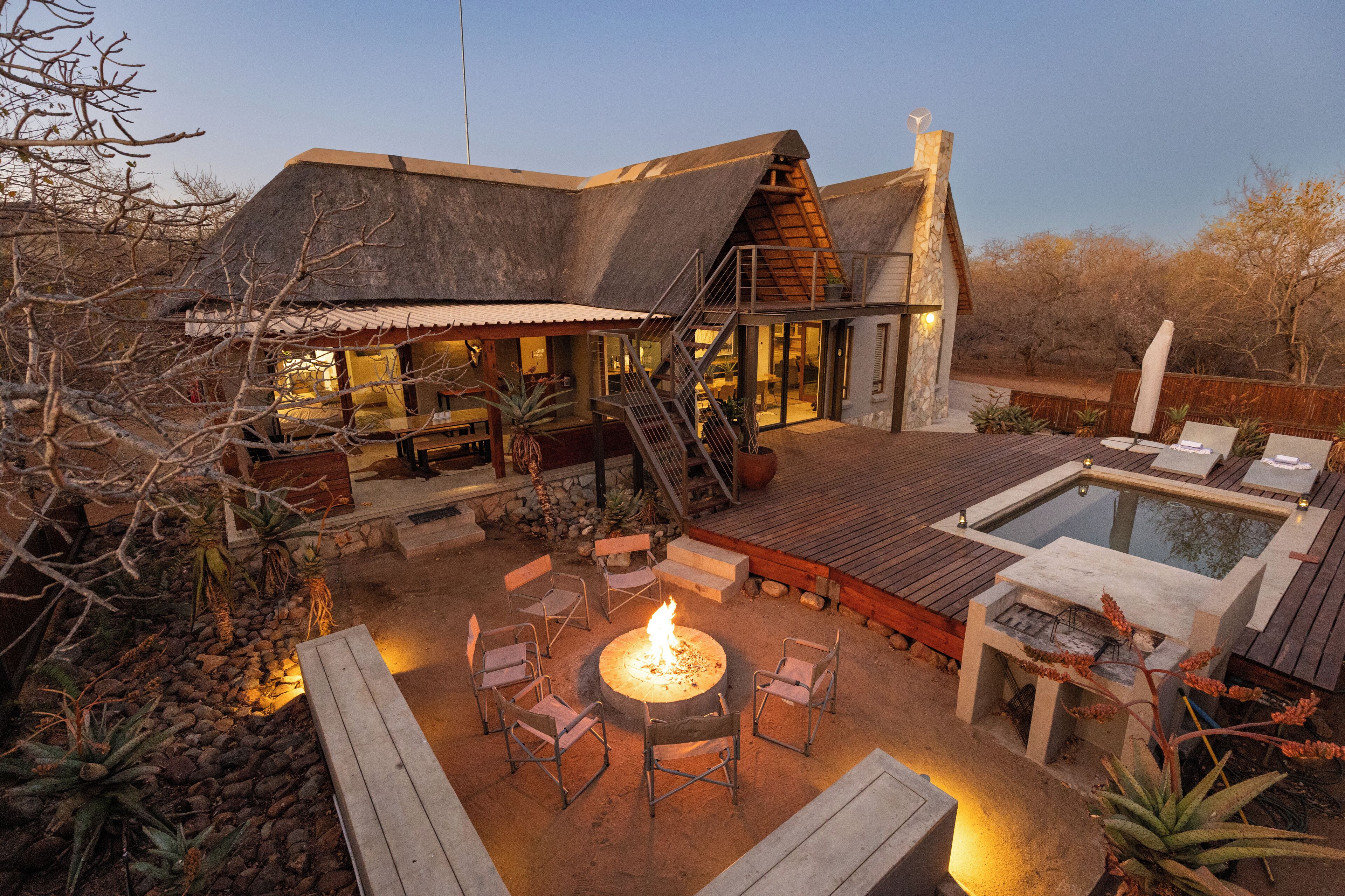 A modern house with a fire pit, outdoor seating, and a swimming pool.