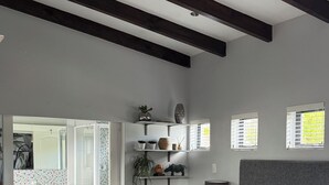 A modern bedroom with a large bed, a bedside table, a lamp, and a window with blinds. - Windsor House (Cape Town)