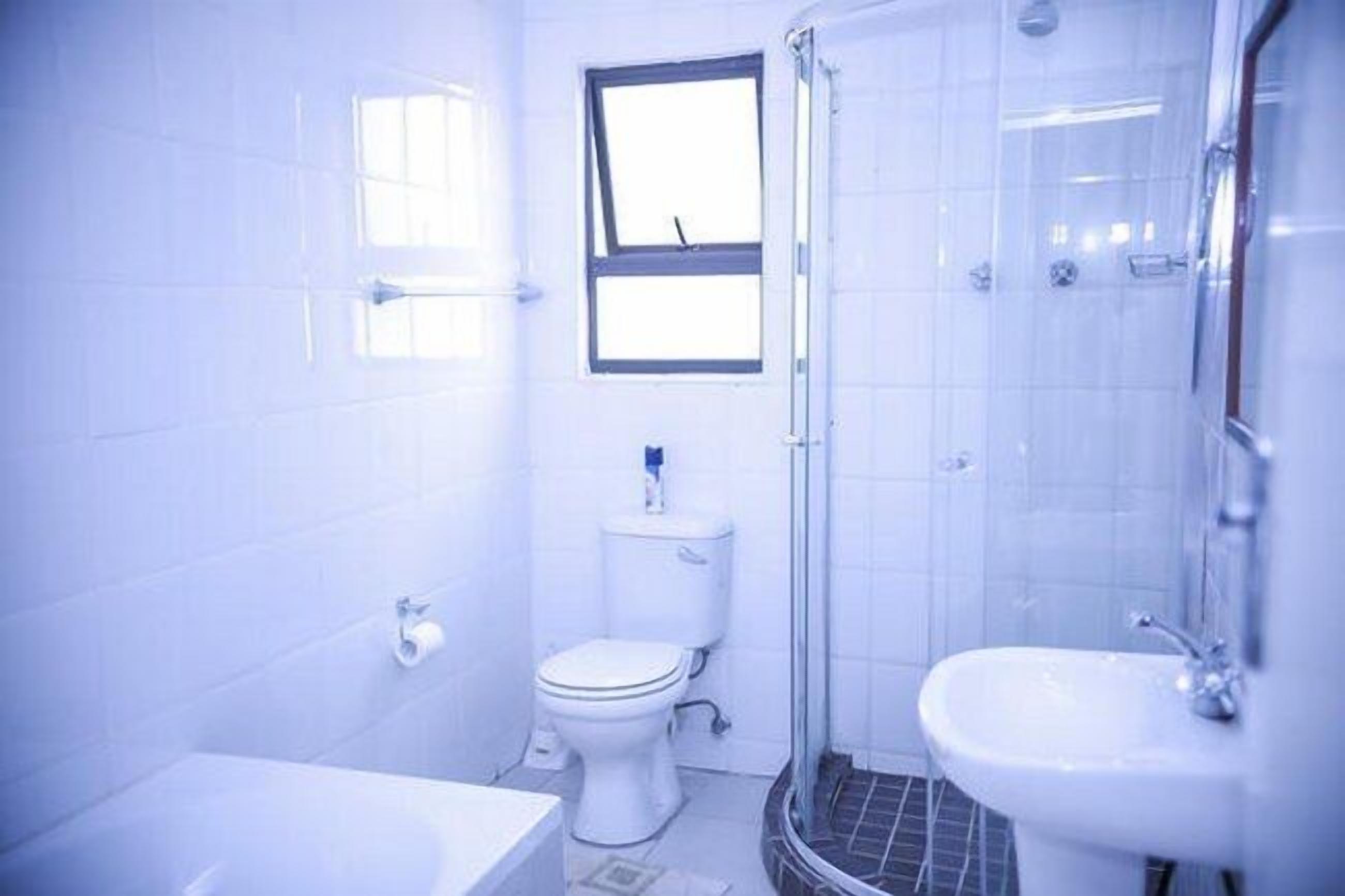 Un baño con inodoro, lavabo y ducha.