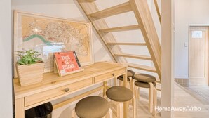 Un bureau en bois, sur lequel se trouvent une carte et un livre intitulé « Voici Osaka », dans une pièce dotée d’un plafond en pente et de poutres en bois.