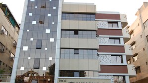 Um hotel com vários andares e fachada moderna, com uma entrada visível e uma placa com a inscrição