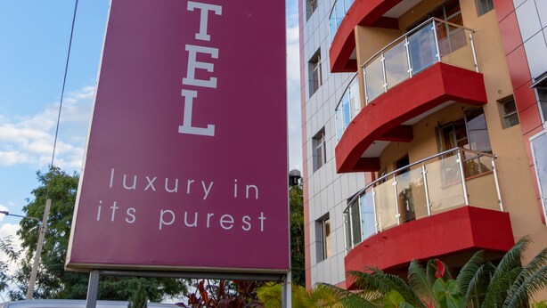 Placa de hotel com o nome 'Eton Hotel' e o slogan 'luxo em sua essência'.
