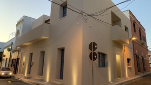 A modern building with a unique triangular facade, multiple windows, and a stop sign. - La Naca sul Mare (Nardò)