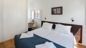 Een hotelkamer met een groot bed, een bureau en een stoel.