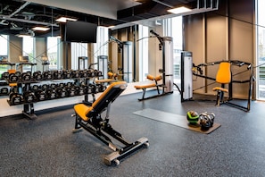 A gym with various exercise equipment, including dumbbells, benches, and a cable machine. - YOTEL Amsterdam (Amsterdam)