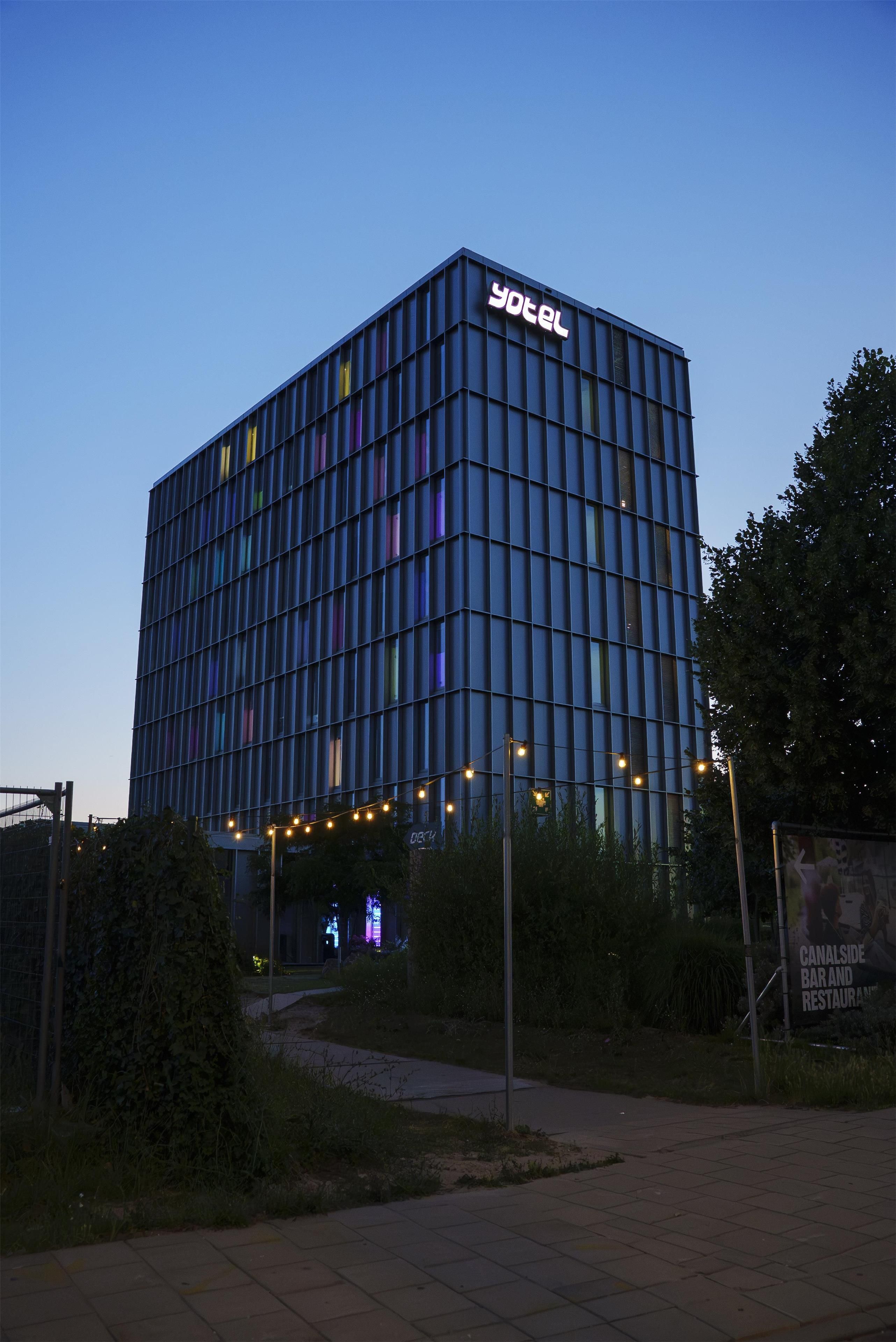 Ein modernes Hotelgebäude mit einem gut sichtbaren 'yotel'-Schild auf dem Dach.