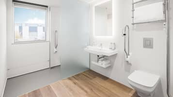 Un baño moderno con inodoro, lavabo y ducha.