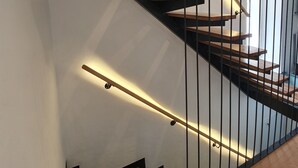 A modern staircase with wooden steps and black metal railings, leading to an upper floor. - The Suites at Central Split (Split)