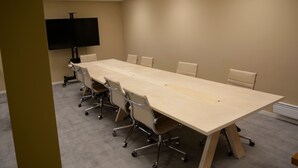 A conference room with a long table and six chairs, a flat-screen TV, and ceiling lights. - 8 Seasons (Nesseby)