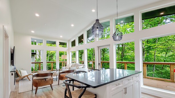 Una cocina amplia con ventanas grandes, un comedor y una terraza de madera.