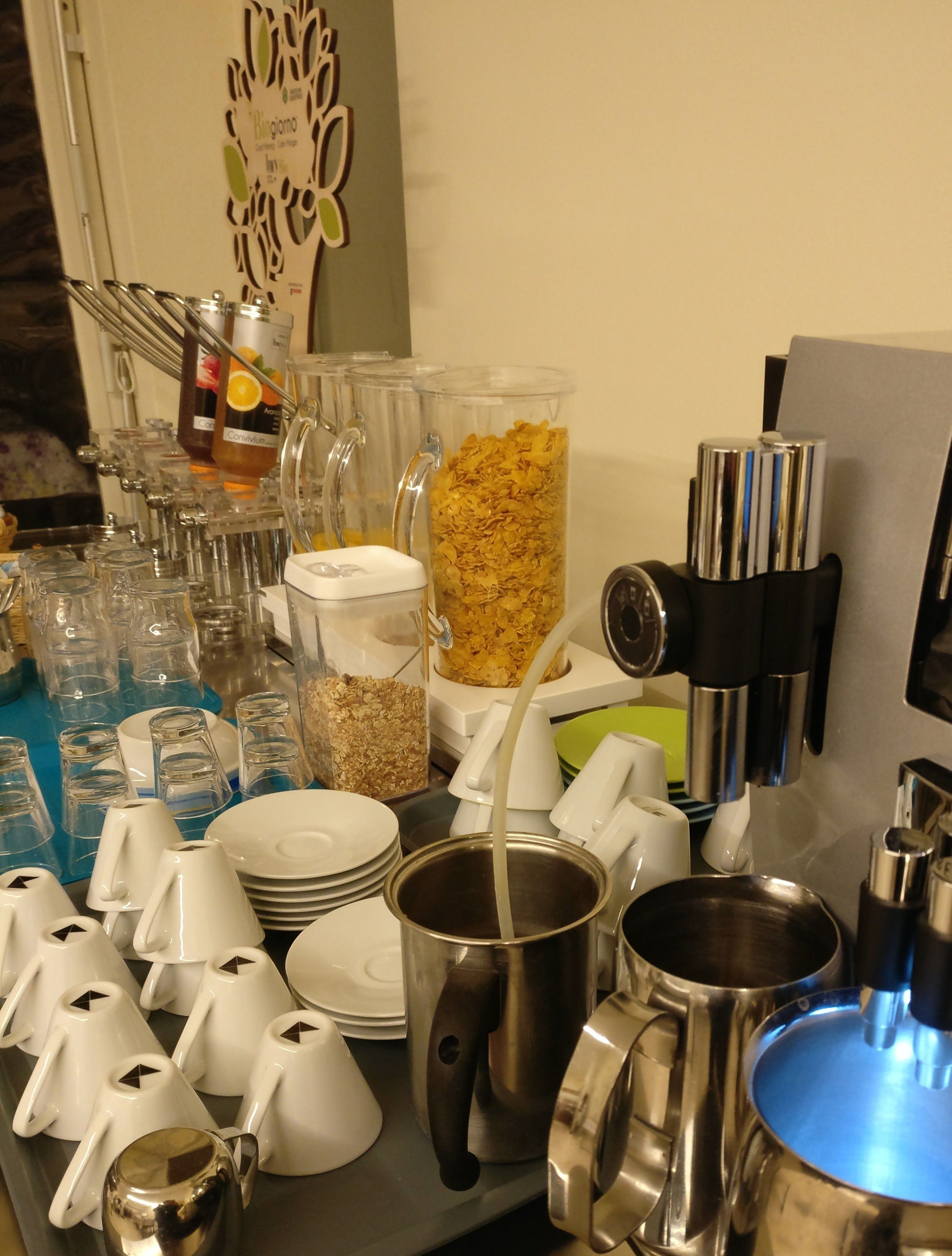 Un buffet proposant une variété d’aliments, notamment des céréales et des boissons, ainsi qu’une machine à café.
