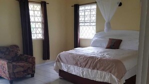 A bedroom with a bed, a chair, and a ceiling fan. - Belle View Rising (Gros Islet)