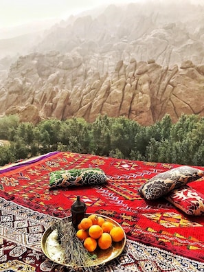 A traditional rug with a mountainous backdrop. - Monkey Finger House (Ait Sedrate Jbel El Soufla)