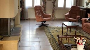 A living room with two armchairs, a coffee table, and a fireplace.