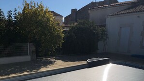 A rooftop with corrugated metal roofing, a concrete edge, and a metal gutter system.