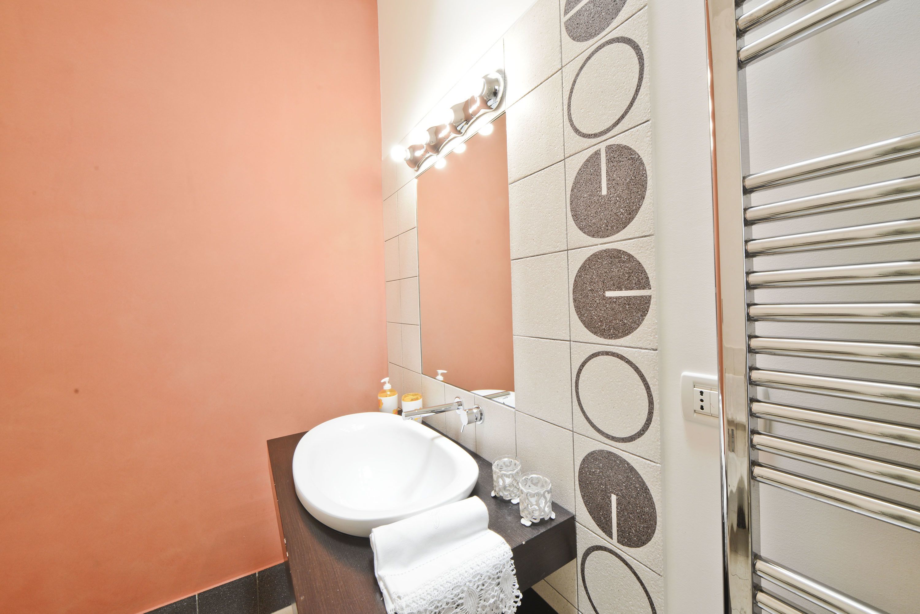A bathroom with a white sink, a mirror, and a towel rack.