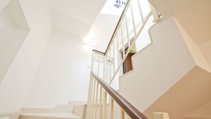 A modern staircase with a wooden handrail and glass railings, leading to an upper floor. - Appartamento Ambra con Balcone by Wonderful Italy (Ostuni)
