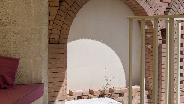 A brick archway leading to a covered outdoor area with a bench and a plant. - Appartamento Ambra con Balcone by Wonderful Italy (Ostuni)