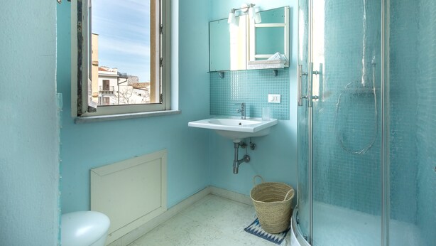 A bathroom with a window, a sink, a mirror, and a shower. - Palazzo Castrofilippo Apartment by Wonderful Italy (Palermo)