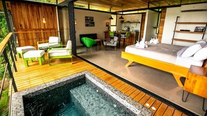 A modern outdoor living area with a pool, wooden deck, and a cozy seating area with a bed. - The Green House - Santa Teresa (Cóbano)