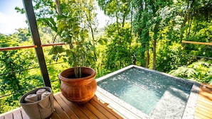 A wooden deck with a hot tub, a potted plant, and a basket of towels. - The Green House - Santa Teresa (Cóbano)