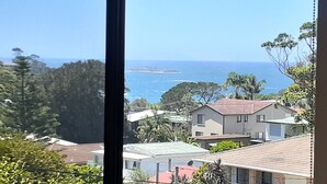 Un quartier résidentiel situé sur la côte, avec des maisons, des arbres et une vue sur la mer.