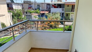 A balcony with tiled flooring, metal railings, and a view of neighboring buildings. - A 3-floor Building With 4 Bedroom, Near Beach (Dërmenas)