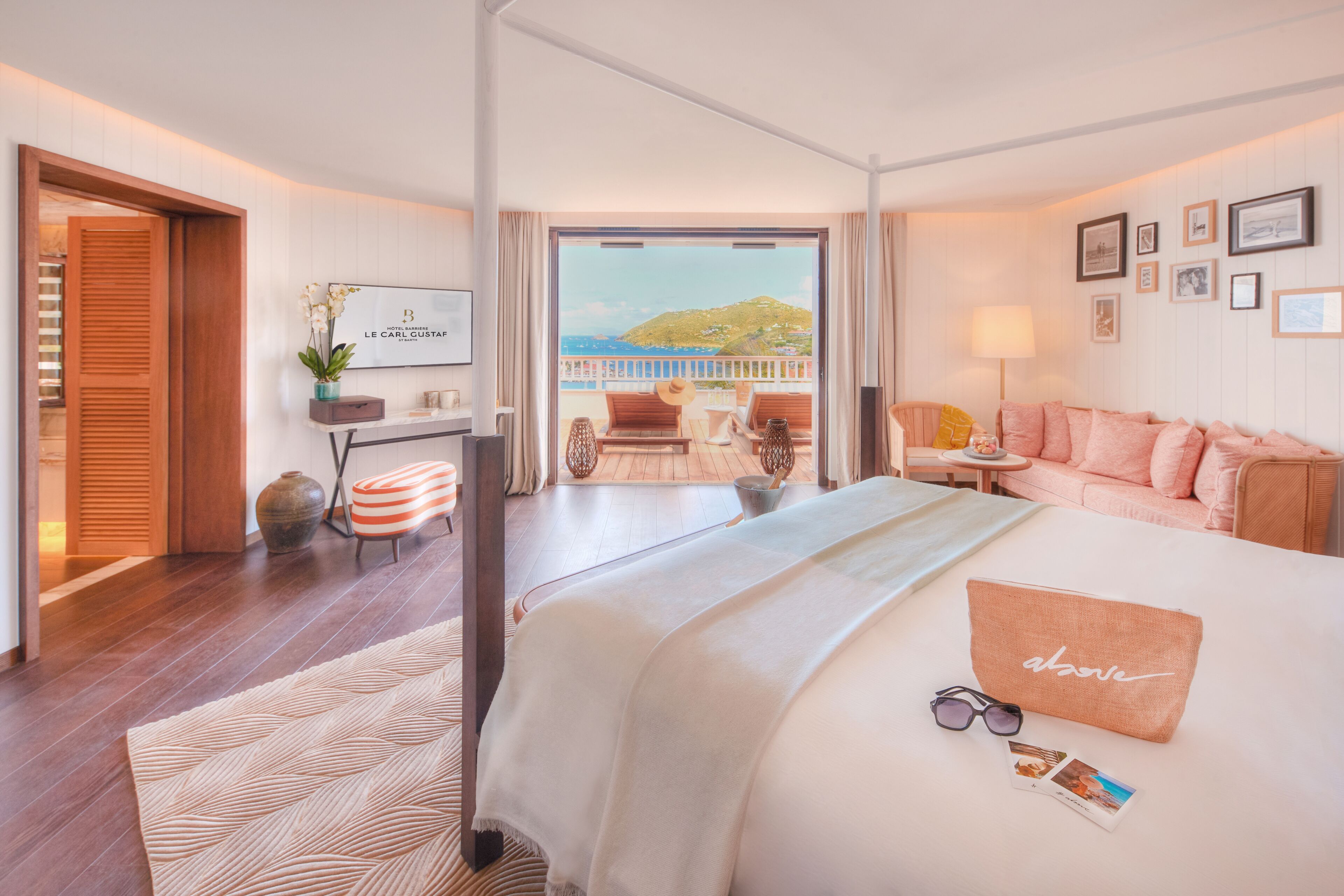 Una habitación de hotel con una cama, un escritorio, una silla, un sofá, un balcón con vistas y un televisor.