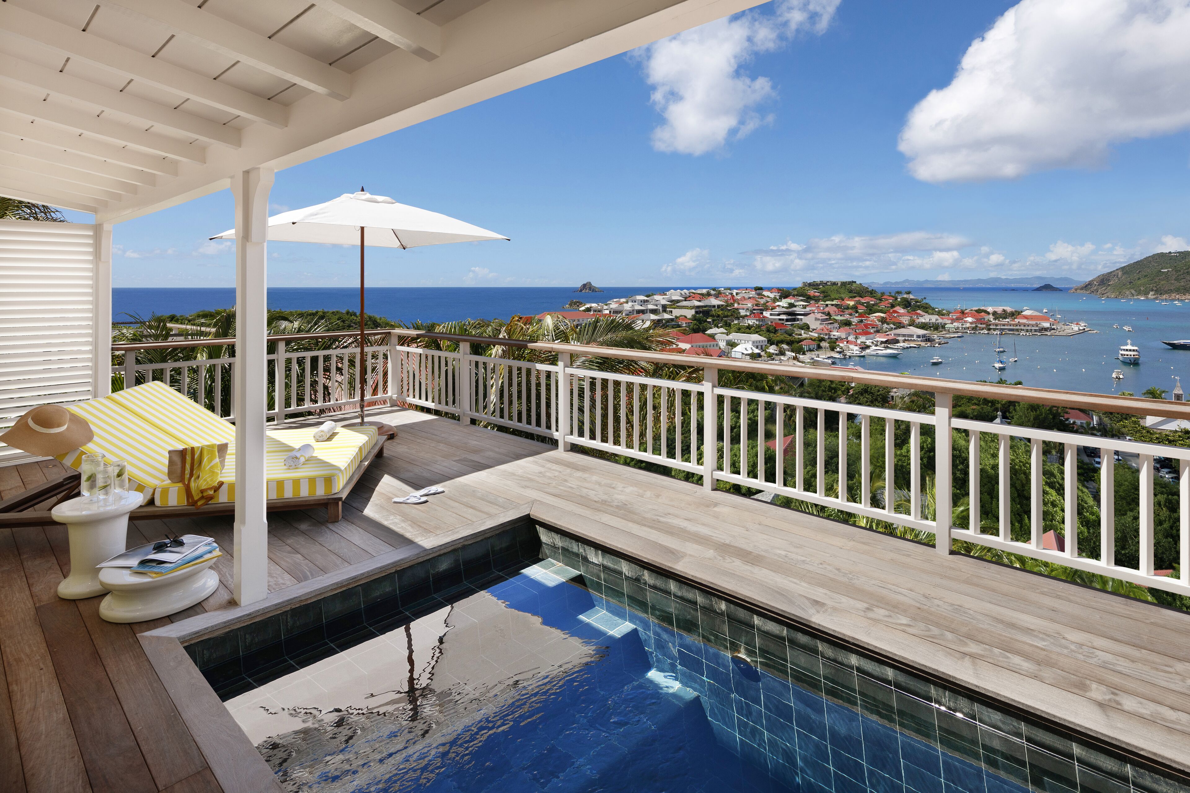 A pool area with a view of the ocean and a town.
