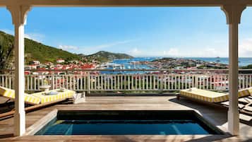 A pool area with a view of a marina and town.