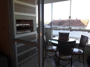 Ein Balkon mit Korbstühlen und einem Tisch, mit Blick auf eine Wohngegend.