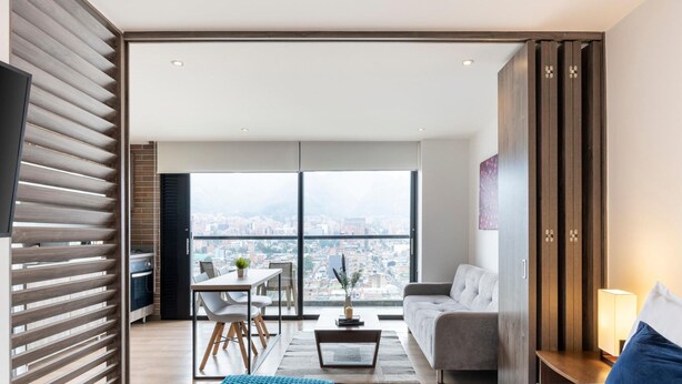 Una sala de estar moderna con vistas a la ciudad, un comedor y un sofá.