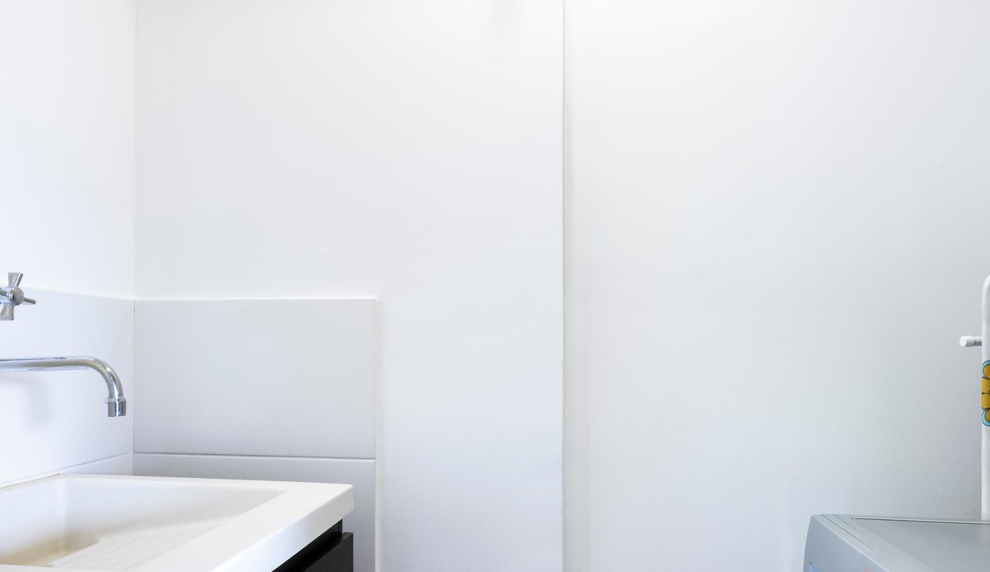 Een moderne badkamer met een wit wastafel, een douchegedeelte en een toilet.