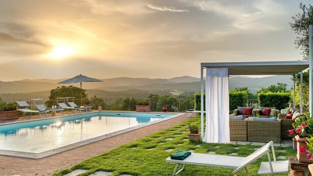 A pool with lounge chairs and a covered seating area, surrounded by a well-maintained lawn and a scenic view of hills. - Villa Gerlino - Country House with private pool (Rapale)