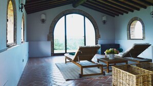 A sunlit patio with a high ceiling, arched windows, and outdoor seating. - Villa Gerlino - Country House with private pool (Rapale)