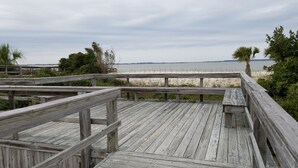 A wooden boardwalk leading to a beach with sand dunes and a view of the ocean. - Tybee Island Ocean Therapy (Tybee Island)