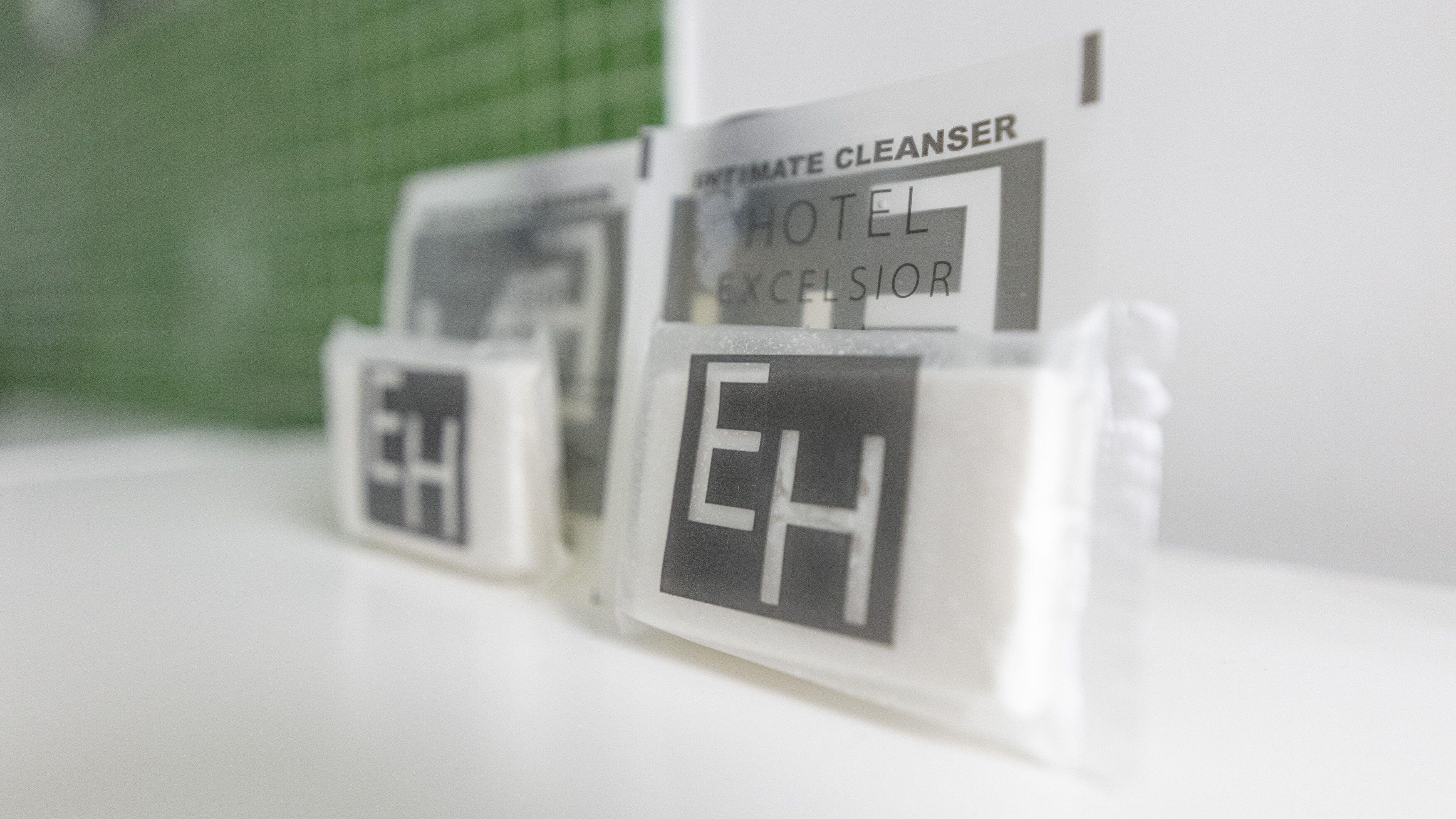 A close-up of hotel room signs with the text "HOTEL EXCELSIOR" and "INTIMATE CLEANSER".