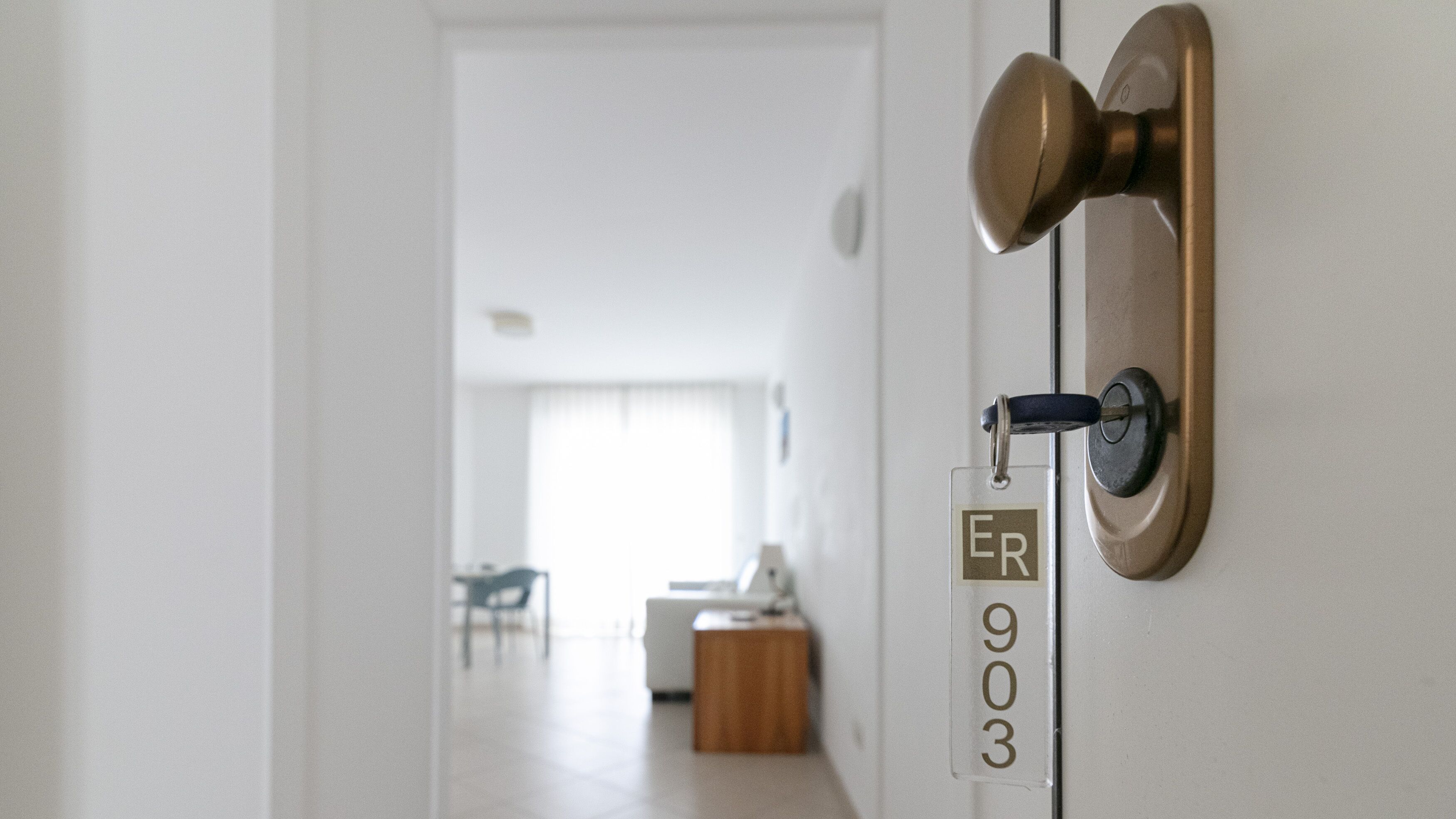 A door with a brass handle and a room number sign.