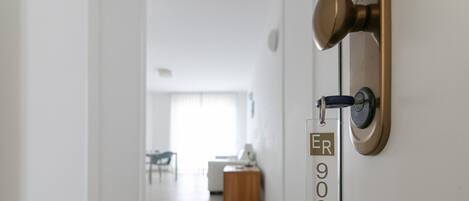 A door with a brass handle and a room number sign.
